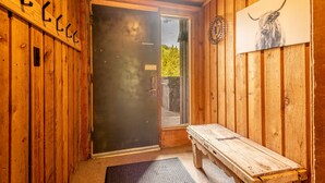 A wooden cabin interior with a bench, a door with a sign, and a bull's head painting. - Ski in/Walk out Center Village condo, Excellent location, Mountain View (copper mountain)