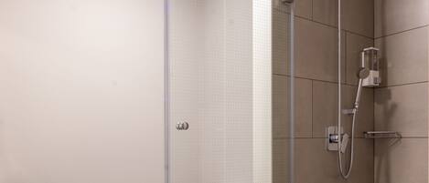 Un baño moderno con ducha de vidrio, inodoro y lavamanos.