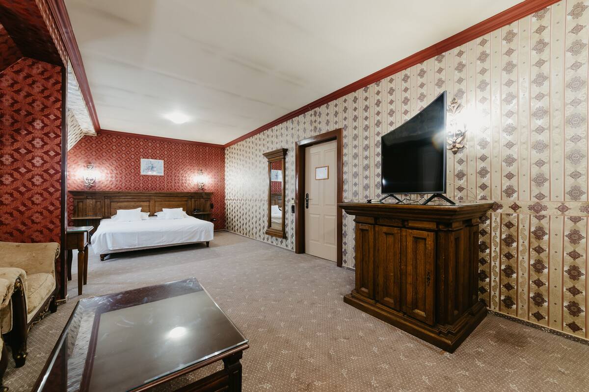 Ein Hotelzimmer mit Bett, Schreibtisch, Fernseher und Kleiderschrank.