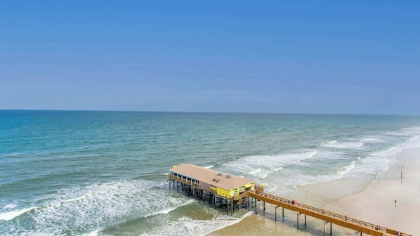 A pier extending into the ocean with a building at the end.