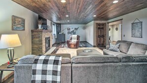 Ein gemütliches Wohnzimmer mit Kamin, Ledersessel und Ecksofa.
