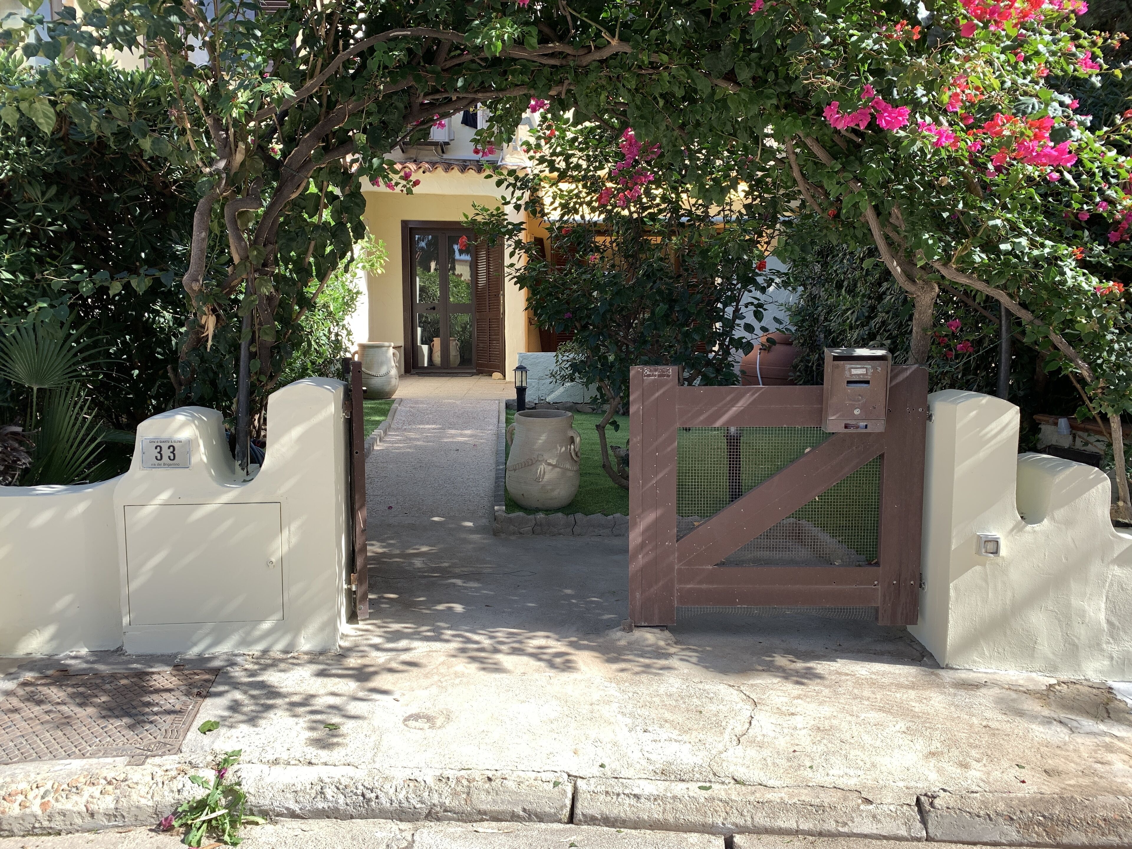 Une entrée fermée par un portail, avec un chemin menant à un bâtiment.