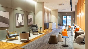 A modern lobby with a wooden floor, seating areas, and artwork on the walls. - Intercity Tatuapé (São Paulo)