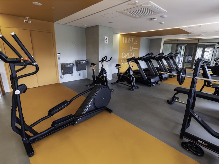 A gym with treadmills, elliptical machines, and weight equipment.