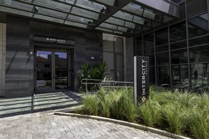The exterior of Intercity Hotels with a modern design, featuring a glass facade and a metal entrance gate. - Intercity Tatuapé (São Paulo)