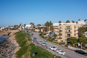 A coastal residential area with a street lined with parked cars and houses. - Oceanfront in La Jolla, Steps to Beach, Shops, Dining | Dawn Patrol by AvantStay (La Jolla)
