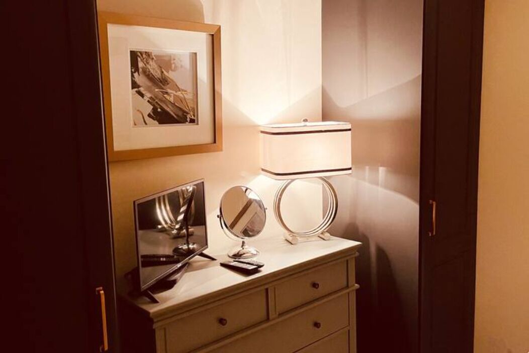 Ein Schminktisch mit Spiegel, einem gerahmten Bild und einer Lampe.
