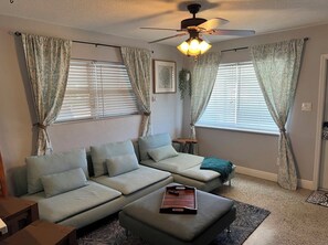 Relax in this inviting living space with a sectional sofa, side table, and decorative tray on the ottoman.
