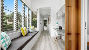 Relax in a serene space with a seating area, desk, and large windows offering a view.
