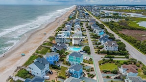 A coastal community with a beach, houses, and a community pool. - Summer Wynd | Ocean Views + Community Amenities! (North Topsail Beach)