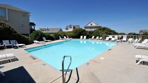 A rectangular swimming pool with a metal ladder in the center, surrounded by white lounge chairs. - Summer Wynd | Ocean Views + Community Amenities! (North Topsail Beach)