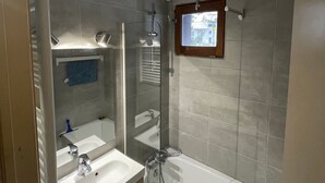 A modern bathroom with a glass-enclosed shower, a large bathtub, and a vanity with a mirror. - Plagne Montalbert Studio 4 people (Montalbert)