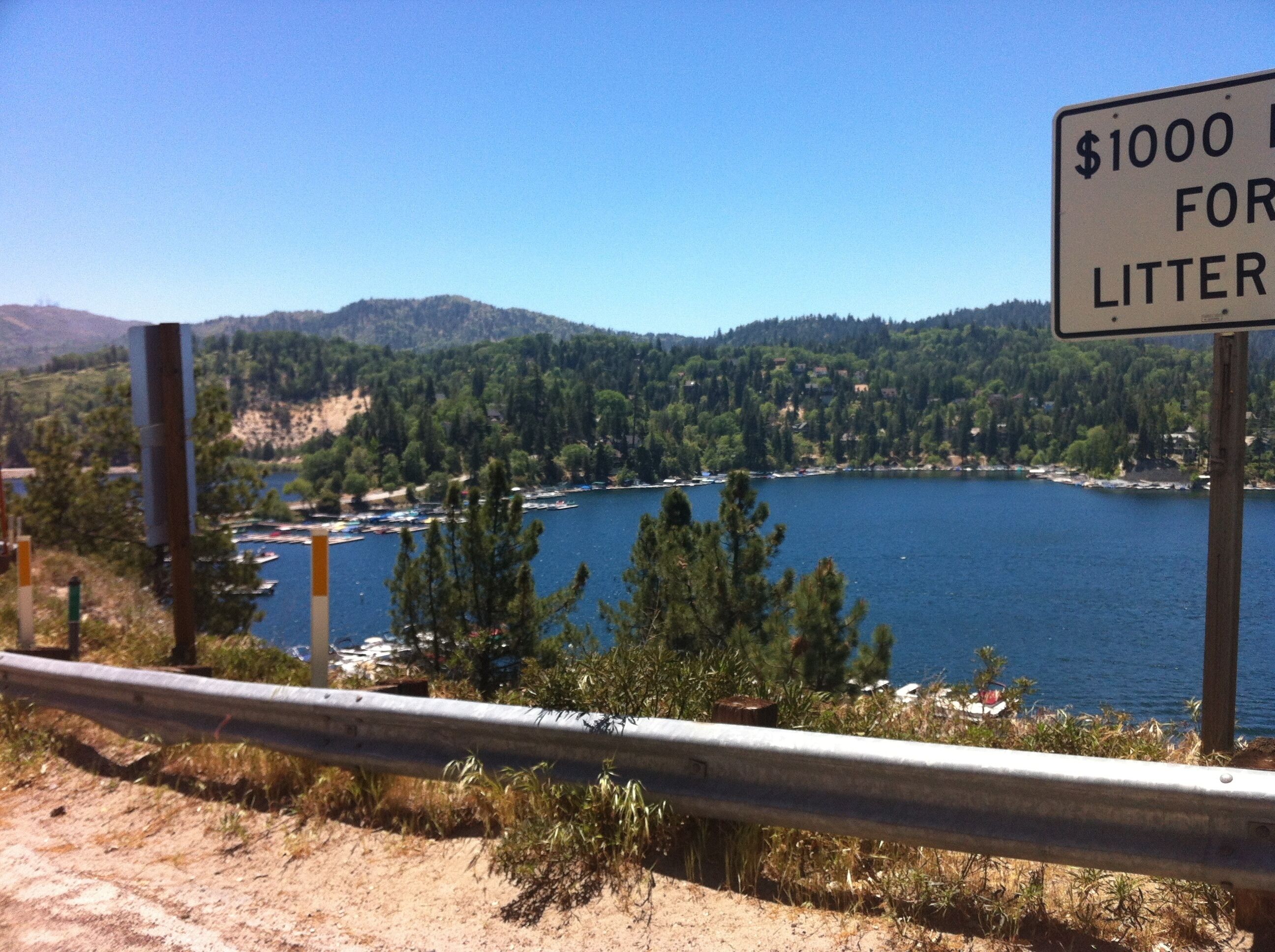 A scenic view of a lake with a sign indicating a $1000 fine for littering.