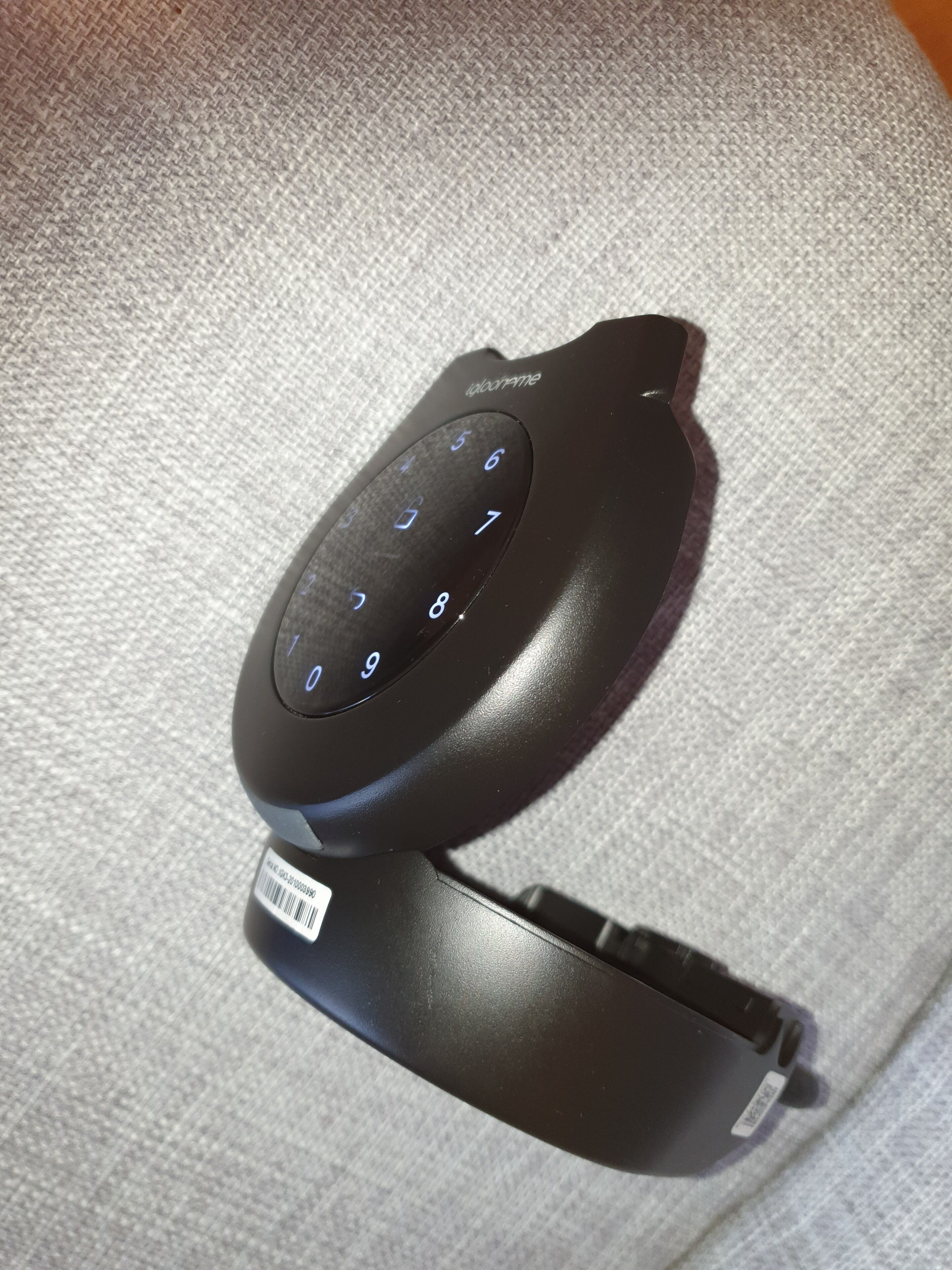 A black telephone keypad with a barcode on a textured surface.