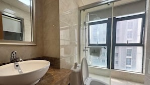 Une salle de bain avec un grand lavabo, des toilettes et une douche à parois de verre.