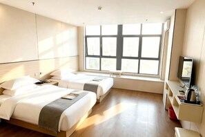 A hotel room with two beds, a large window, a TV, and a desk with a kettle. - Bailandi Boutique Hotel (Kunshan)