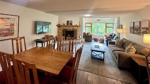 Una sala de estar con chimenea, una mesa de comedor y un sofá.