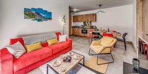 Een moderne woonkamer met een rode bank, een salontafel en een eethoek met rode stoelen.