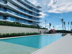 Relax by the pool with lounge chairs and umbrellas, surrounded by the hotel's contemporary architecture.