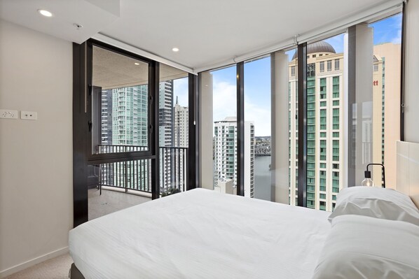 Enjoy city views from the large window in this stylish room, featuring a king-size bed and convenient bedside table.
