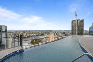 Enjoy breathtaking city views from the rooftop pool, surrounded by a glass railing and overlooking the river and bridge.