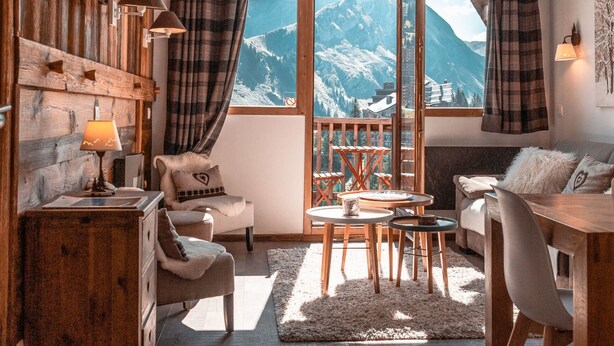 A cozy room with a wooden interior, a dining area, and a large window offering a mountain view. - Immodreams - La Marmotte - Avoriaz (Avoriaz)