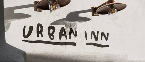 Une enseigne indiquant « URBAN INN », avec deux luminaires placés au-dessus.