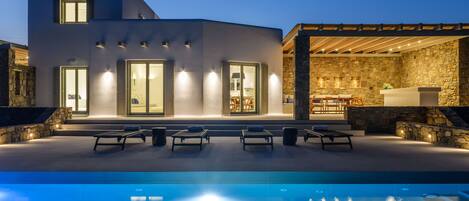Una piscina al aire libre, tumbonas