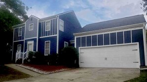 A two-story house with a white garage door, a front porch with white railings, and a driveway leading to the garage. - Cozy home minutes from PNC and Nascar Speedway (Charlotte)
