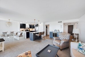 A modern living room with a dining area, a kitchen, and a small island.