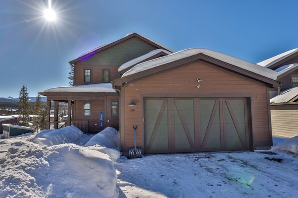 A two-story house with a garage, surrounded by snow, under a clear sky. - Elevated Mountain Retreat—Private, Spacious, Minutes from Adventure (Fraser)
