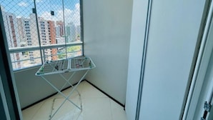 A balcony with a metal drying rack and a view of tall buildings.