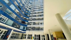 A multi-story residential building with balconies, large windows, and a modern architectural design.