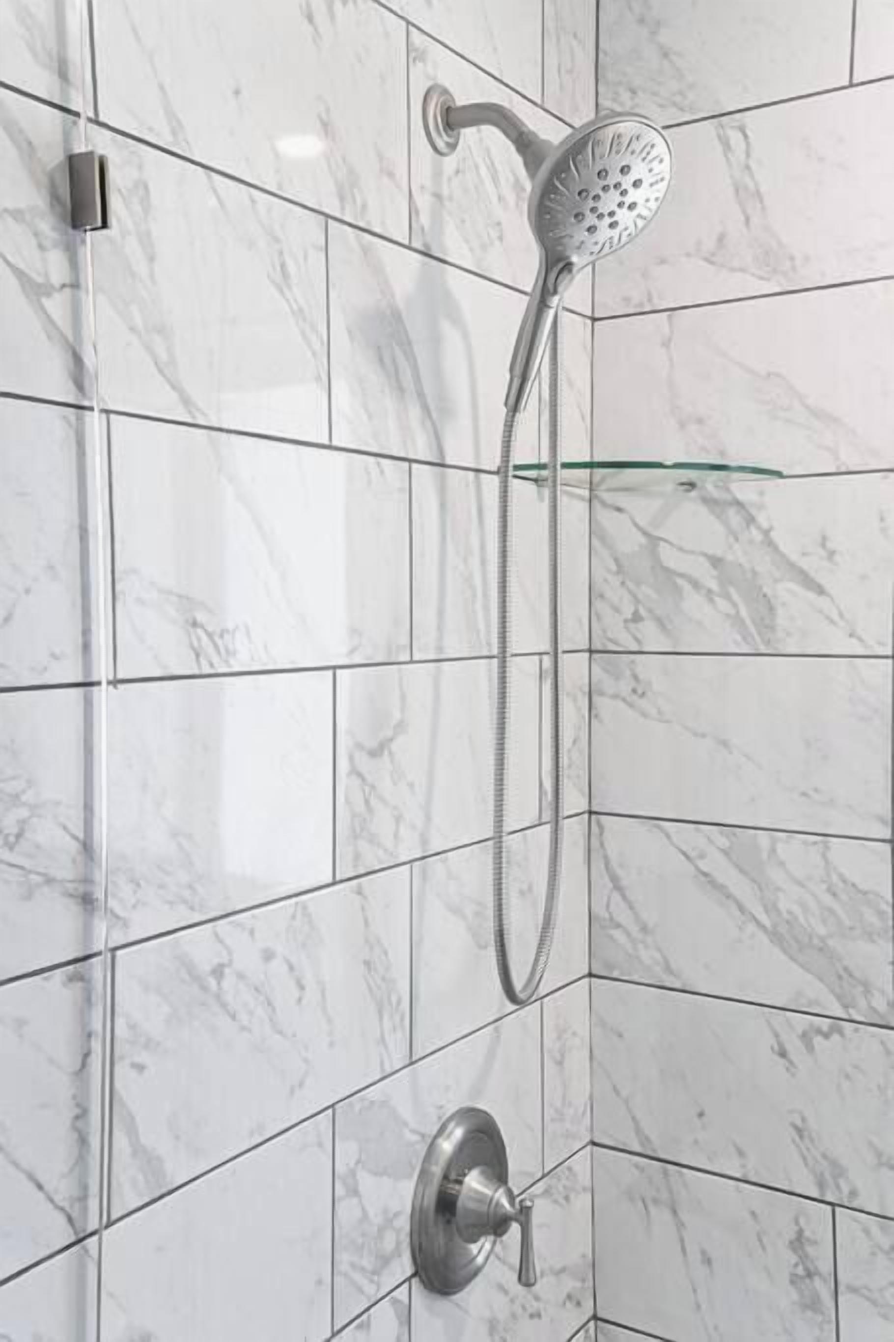 Une douche équipée d’un pommeau de douche à main et de commandes murales.
