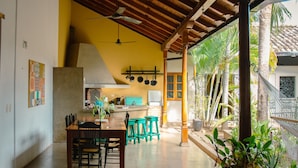 A spacious kitchen with a dining area, a ceiling fan, and a view of the outdoors. - Miskitu Casa Boutique (Granada)