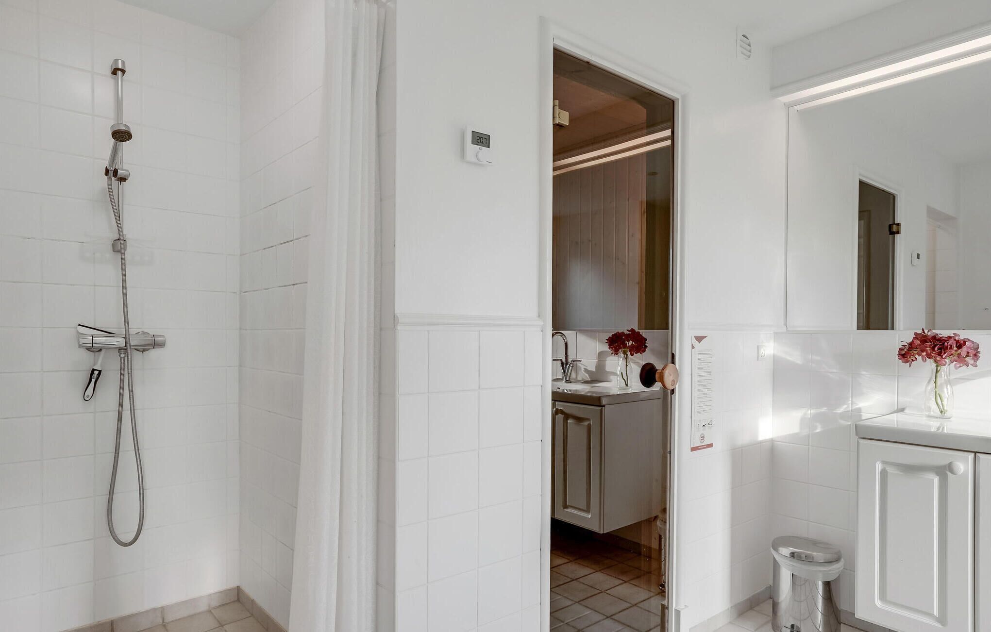 Une salle de bain avec douche, toilettes et lavabo.