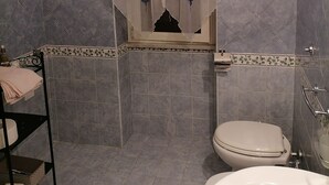 A bathroom with a shower, toilet, and sink.