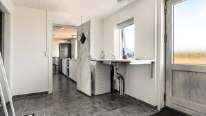 A modern kitchen with a built-in oven, a sink, and a window.