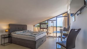 A modern bedroom with a large bed, a bedside table, a chair, and a view of the outdoors. - Beautiful apartment in Medulin with swimming pool (Medulin)