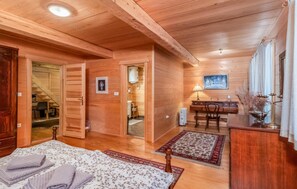 Ein gemütliches Holzhaus-Interieur mit Bett, Schreibtisch und Badezimmer.
