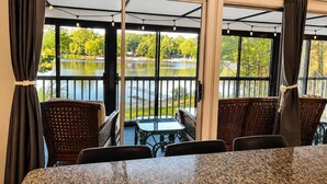 Una habitación con vistas a un lago, una mesa y sillas.