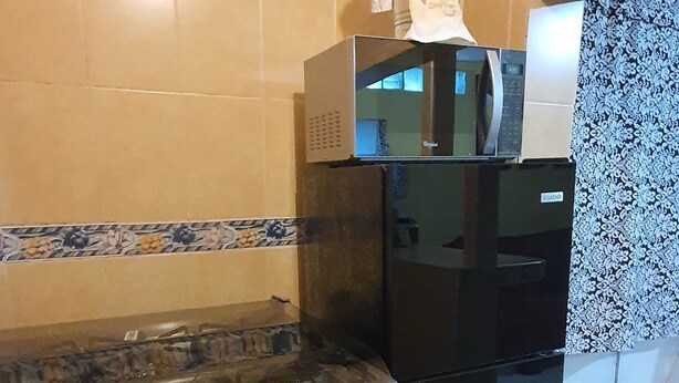 Una cocina equipada con estufa, horno, microondas y refrigerador.