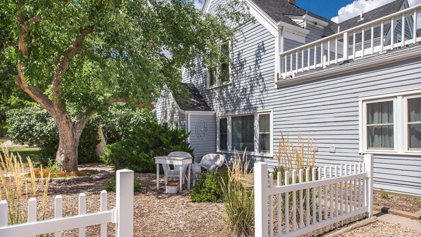A house with a white picket fence, a patio with outdoor furniture, and a tree in the yard. - Historic District, Downtown, STE 1 (Rapid City)
