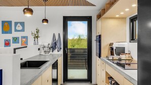 A modern kitchen with a large window, a stand mixer, and a coffee machine.