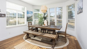 A dining area with a wooden table, benches, and a hanging light fixture. - Clockers House at Galway - 3 bedroom, 3 bath luxury home on-site of Galway Downs (Temecula)