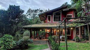 A two-story house with a covered patio and a dining area. - Casa na Serra de Mulungu por Carpediem (Mulungu)