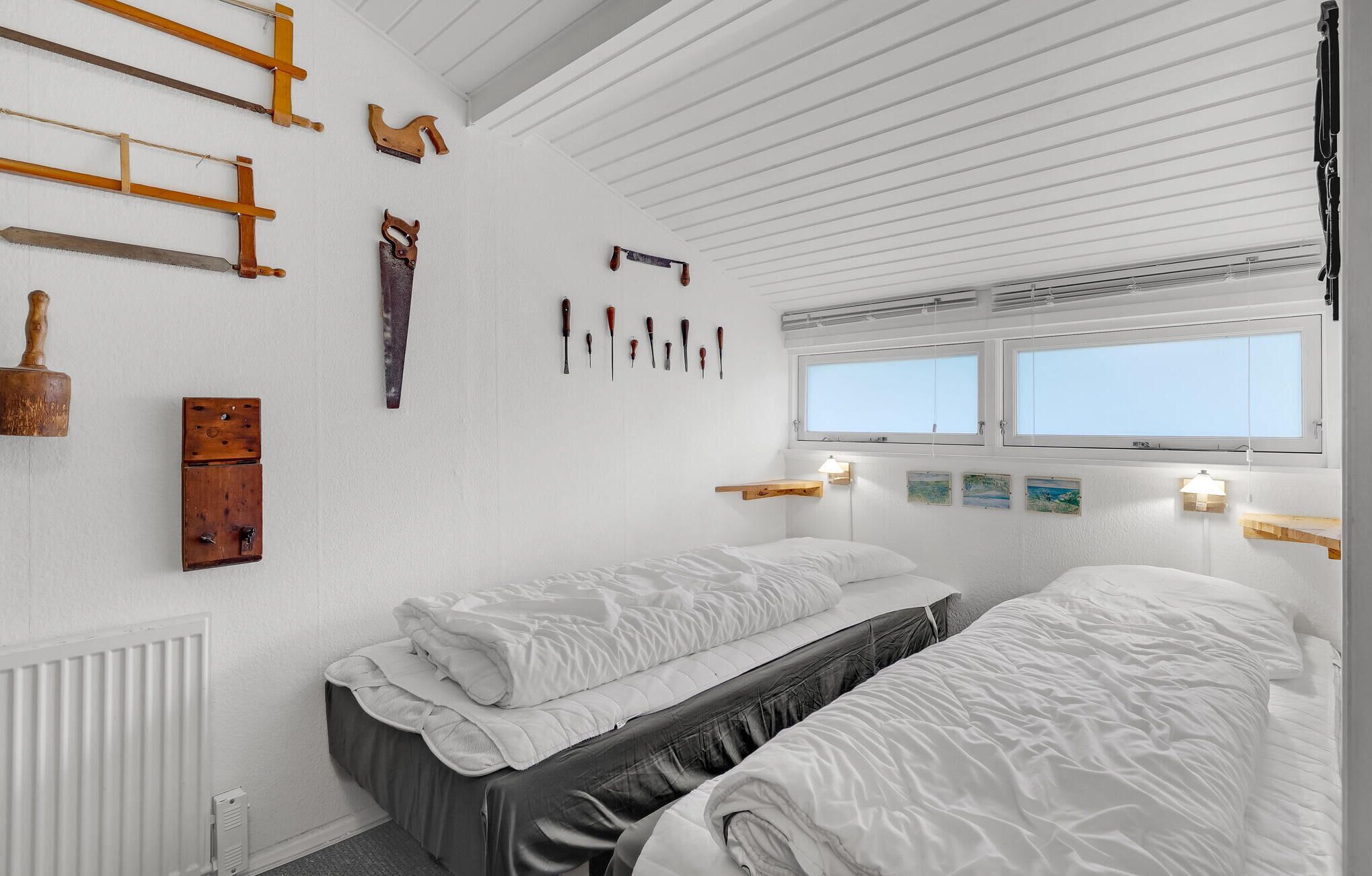 A room with two beds, wooden wall decorations, a window, and a radiator.
