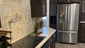 A modern kitchen with dark wooden cabinets, stainless steel appliances, and a tiled backsplash. - 10 acres, for dirtbikes+ near Death Valley, casinos and wineries, Stargazing ect (Pahrump)