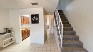 Una cocina amplia con armarios de madera, un refrigerador blanco y una isla central con una cafetera.