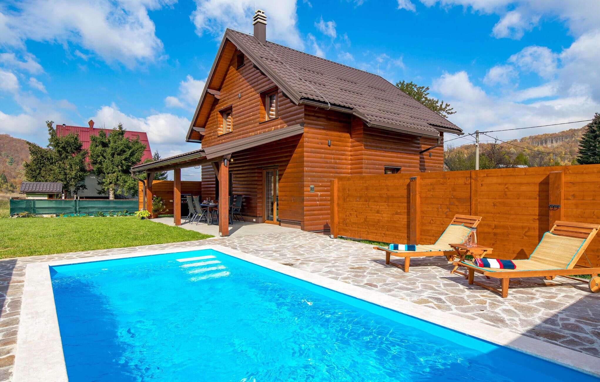 Une cabane en bois avec une piscine et un espace salon extérieur.